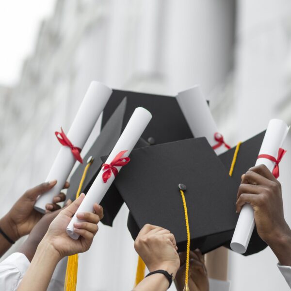 close-up-hands-holding-diplomas-caps